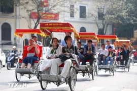 International tourists take a cyclo tour around Hoan Kiem Lake in Hanoi. (Photo: VNA)