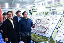 Prime Minister Pham Minh Chinh (R) visits the production line of THACO Group. (Photo: VNA)