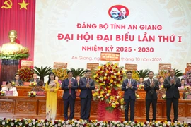 General Phan Van Giang, Politburo member, Deputy Secretary of the Central Military Commission, and Minister of National Defence, presents a flower basket on behalf of the Communist Party of Vietnam Central Committee to congratulate the congress. (Photo: VNA) 