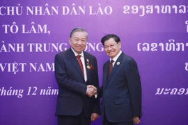 General Secretary of the Central Committee of the Lao People's Revolutionary Party and President of Laos Thongloun Sisoulith (right) congratulates General Secretary of the Central Committee of the Communist Party of Vietnam To Lam on receiving the National Gold Medal - the highest honour of Laos (Photo: VNA)