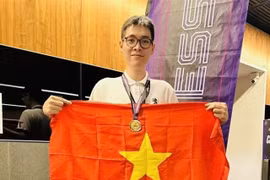 Le Tuan Minh holds the national flag to celebrate his win in rapid chess event of the Asian Mind Sports Conference & Festival which closed on November 15 in Singapore. (Photo: VNA)