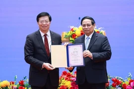 Prof. Dr. Qiu Yong (L), Secretary of the Tsinghua University’s Party Committee and Academician of the Chinese Academy of Sciences presents the "Honorary Professor" title to PM Pham Minh Chinh. (Photo: VNA)