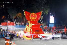 A parade float bearing the national emblem of the Socialist Republic of Vietnam takes part in the second full rehearsal for the upcoming military parade and mass procession celebrating national reunification. (Photo: VNA)