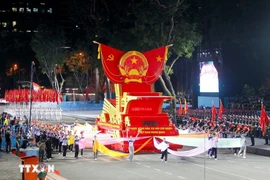A parade float bearing the national emblem of the Socialist Republic of Vietnam takes part in the second full rehearsal for the upcoming military parade and mass procession celebrating national reunification. (Photo: VNA)