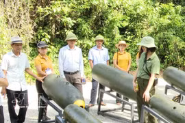 Tourists visit the exhibition area displaying various types of bomb casings at the "Legendary Truong Son Road - Command Cave" eco-tourism site in Quang Tri province (Photo: VNA)