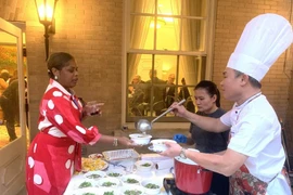 People enjoy beef "pho" - a traditional dish seasoned with typical Vietnamese spices at the event. (Photo: VNA)