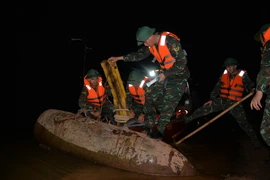 Soldiers handle an unexploded wartime bomb found near an alluvial islet in the Red River. (Photo: VNA)