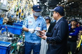 Chairman of the Hanoi Federation of Labour Pham Quang Thanh (R) visits a business in Hanoi on February 3 (Photo: VNA)