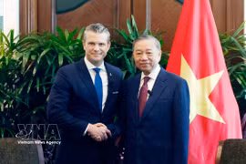 General Secretary of the Communist Party of Vietnam Central Committee and State President To Lam (right) and US Secretary of War Pete Hegseth pose for a commemorative photo. (Photo: VNA)