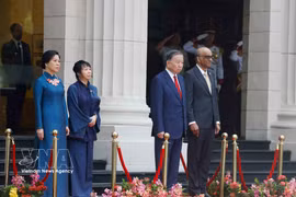 Party General Secretary and State President To Lam and Singaporean President Tharman Shanmugaratnam, together with their spouses, stand on the podium of honour as military bands perform the national anthems of Vietnam and Singapore at the welcome ceremony on May 29 morning. (Photo: VNA) 
