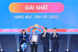 Deputy Prime Minister Mai Van Chinh (second, right), Minister of Science and Technology Nguyen Manh Hung (first, right), and Chairwoman of the Vietnam Association of Photographic Artists Tran Thi Thu Dong (first, left) present insignia and certificate to the first-prize winner. (Photo: VNA) 