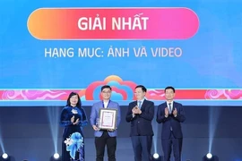 Deputy Prime Minister Mai Van Chinh (second, right), Minister of Science and Technology Nguyen Manh Hung (first, right), and Chairwoman of the Vietnam Association of Photographic Artists Tran Thi Thu Dong (first, left) present insignia and certificate to the first-prize winner. (Photo: VNA) 
