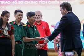 US Ambassador to Vietnam Marc Evans Knapper hands over wartime artifacts to families of fallen soldiers and veterans. (Photo: VNA)