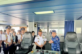 A Vietnam Coast Guard officer (first, right) introduces vessel CBS 8001 to delegates. (Photo: VNA)
