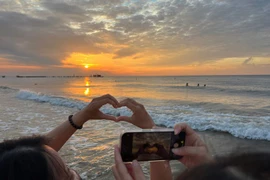 Tourists enjoy the sunrise moment in Mui Ne. (Photo: VNA)