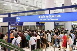 People queue up to board the train at Ben Thanh Station on the first day of operation of Metro Line 1 (Photo: VNA)