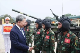 Party General Secretary To Lam, Secretary of the Central Military Commission, shakes hands with a serviceman of the Tank-Armored Corps. (Photo: VNA)