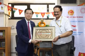 Ambassador Nguyen Thanh Hai (left) presents the representative of the Indian Central Secretariat Library with a picture of Vietnamese stamps. (Photo: VNA)