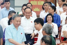 Party General Secretary To Lam (first, left) and members of Hanoi's delegation of NA deputies meets with voters of nine communes in Hanoi (Photo: VNA)