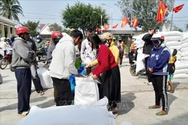 People in difficult circumstances receive rice aid on the occasion of the Lunar New Year Festival in Lak district, Dak Lak province. (Photo: VNA)