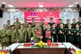 The Quang Tri Border Guard Command and the police of Laos' Salavan province sign the minutes of their annual talks on December 26. (Photo: released by VNA)