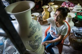 A worker creates patterns for Bat Trang ceramic products. (Photo: VNA)