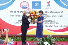 A representative of Prensa Latina News Agency in Vietnam presents flowers to General Director of the Vietnam News Agency Vu Viet Trang to congratulate the agency on the occasion of the 100th anniversary of Vietnamese Revolutionary Press Day. (Photo: VNA)