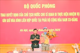 Deputy Minister of National Defence Senior Lieutenant General Hoang Xuan Chien, head of the ministry's steering committee for the participation in UN peacekeeping operations presents the decision to Major Le Vinh Hoang. (Photo: VNA)