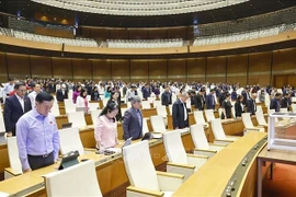 National Assembly deputies observe a minute of silence in remembrance of those who lost their lives to natural disasters and floods on November 24. (Photo: VNA)
