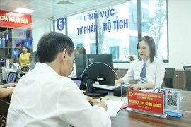 Processing administrative procedures at the public service centre of Dong Da commune in Hanoi (Photo: VNA)