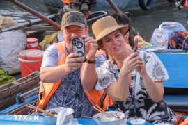 Foreign tourists experience floating market in Can Tho (Photo: VNA)