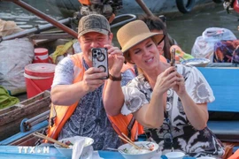 Foreign tourists experience floating market in Can Tho (Photo: VNA)