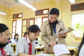 A teacher guiding her students in revision ahead of an examination. (Photo: VNA)