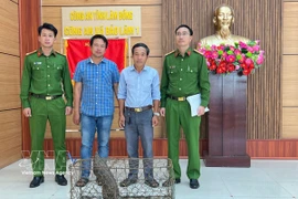 Doan Hong Hai (third from left) hands over a rare pangolin to the authorities of Bao Lam I commune. (Photo: VNA)