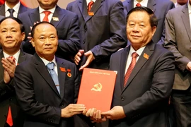 Chairman of the Party Central Committee's Commission for Information, Education, and Mass Mobilisation Nguyen Trong Nghia (R) presents the Politburo's decision to Thai Dai Ngoc, who now serves as Secretary of the Gia Lai provincial Party Committee. (Photo: VNA)