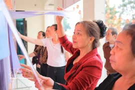 People read information about candidates at polling station No. 6 in Hanoi. (Photo: VNA)