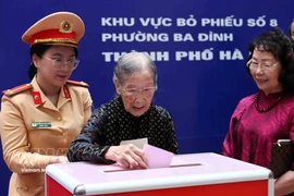 101-year-old voter Doan Thi Thuan (centre) casts her ballot at the polling station at Phan Chu Trinh primary school, Ba Dinh ward, Hanoi. (Photo: VNA)