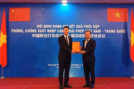 A representative of the Vietnamese delegation presents a souvenir to the Chinese delegation's representative at the conference (Photo: cand.com.vn)