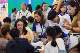 Parents bring their children to the Equitable Education Fund's 'Mobile School' Open House at the Klong Toey slum community in Bangkok in July last year. (Photo: Bangkokpost.com)