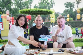 International visitors experience drinking West Lake lotus-infused tea (Photo: VNA)