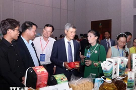 Vietnamese Ambassador to Cambodia Nguyen Minh Vu and Cambodian businesspeople visit the Vietnamese booth. (Photo: VNA)