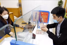 A customer conducts transactions at a bank in Hanoi. (Photo: VNA)