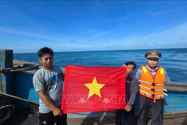 Alongside inspections, since early 2025, the unit has presented 188 national flags to encourage fishermen as they head offshore. (Photo: VNA)