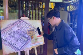 A tourist tries a feature at the culture - heritage - technology experience space within Phu Noi Vu (Internal Affairs Office) of the Hue Imperial Citadel. (Photo: laodong.vn)