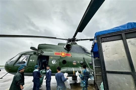 Relief supplies are loaded onto a helicopter for delivery to residents who remain isolated by floodwaters in the south-central provinces. (Photo: VNA)
