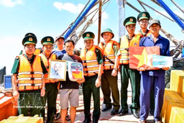 Can Tho border guards present national flags, portraits of President Ho Chi Minh and medicine cabinets to local fishermen. (Photo: VNA)