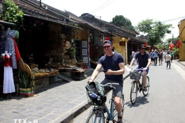 International visitors explore and experience the cultural space of the ancient streets in Hoi An. (Photo: VNA)