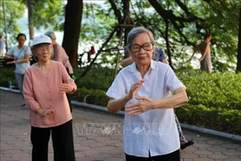 Elderly people do morning exercises in the Hoan Kiem Lake area in Hanoi. (Photo: VNA)