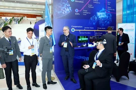 Delegates visit the United Nations technology exhibition space at the Hanoi Convention Opening Ceremony. (Photo: VNA)