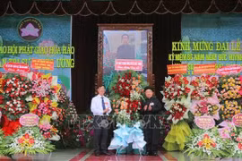 Bui Van Tang (left), Vice President of the Vietnam Fatherland Front Committee of An Giang province, extends congratulations at the grand ceremony marking the 86th founding anniversary of Hoa Hao Buddhism on June 13. (Photo: VNA)